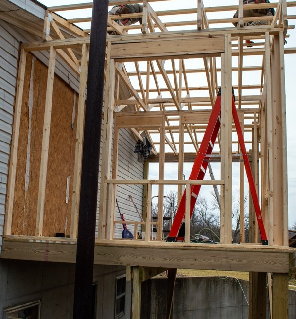 Unrecognizable workers are intent on doing a good construction job with the addition of a new room on this home.