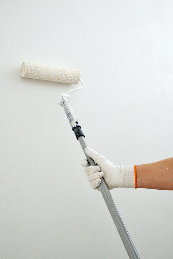 Close,Up,Of,Extended,Roller,Painting,High,Ceiling,Or,Upper Close up of extended roller painting high ceiling or upper wall area during renovation